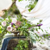 Hochzeit im Freien. Blumenarrangement mit Lavendel und Rosen. Hochzeitsdekoration