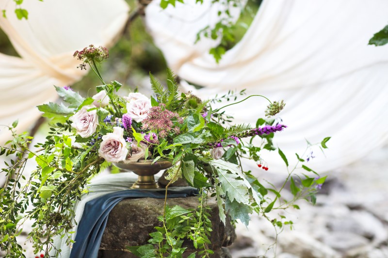 Hochzeit im Freien. Blumenarrangement mit Lavendel und Rosen. Hochzeitsdekoration